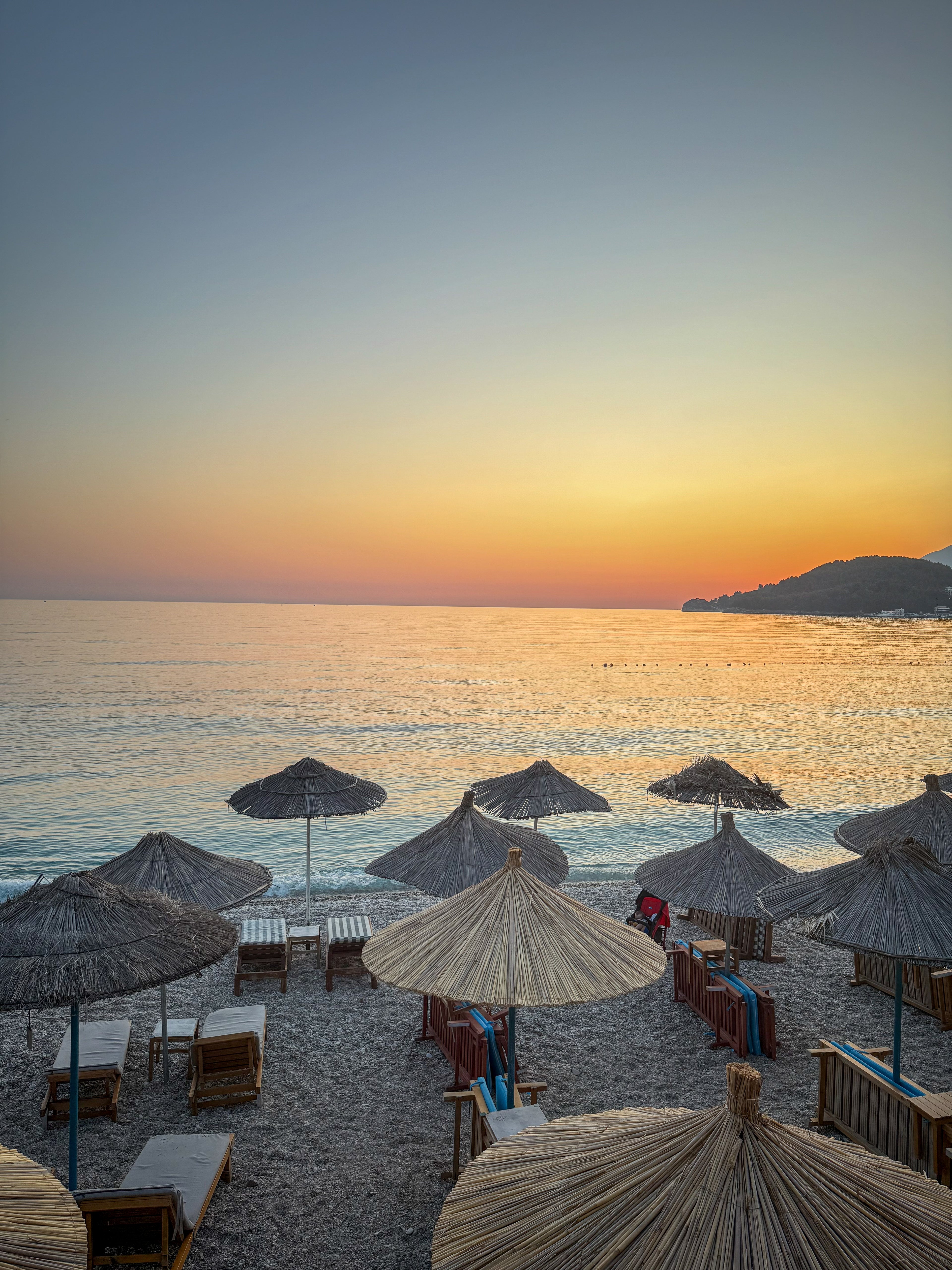 Straw beach umbrellas at dusk in Himare, Albania – photographic wall art print