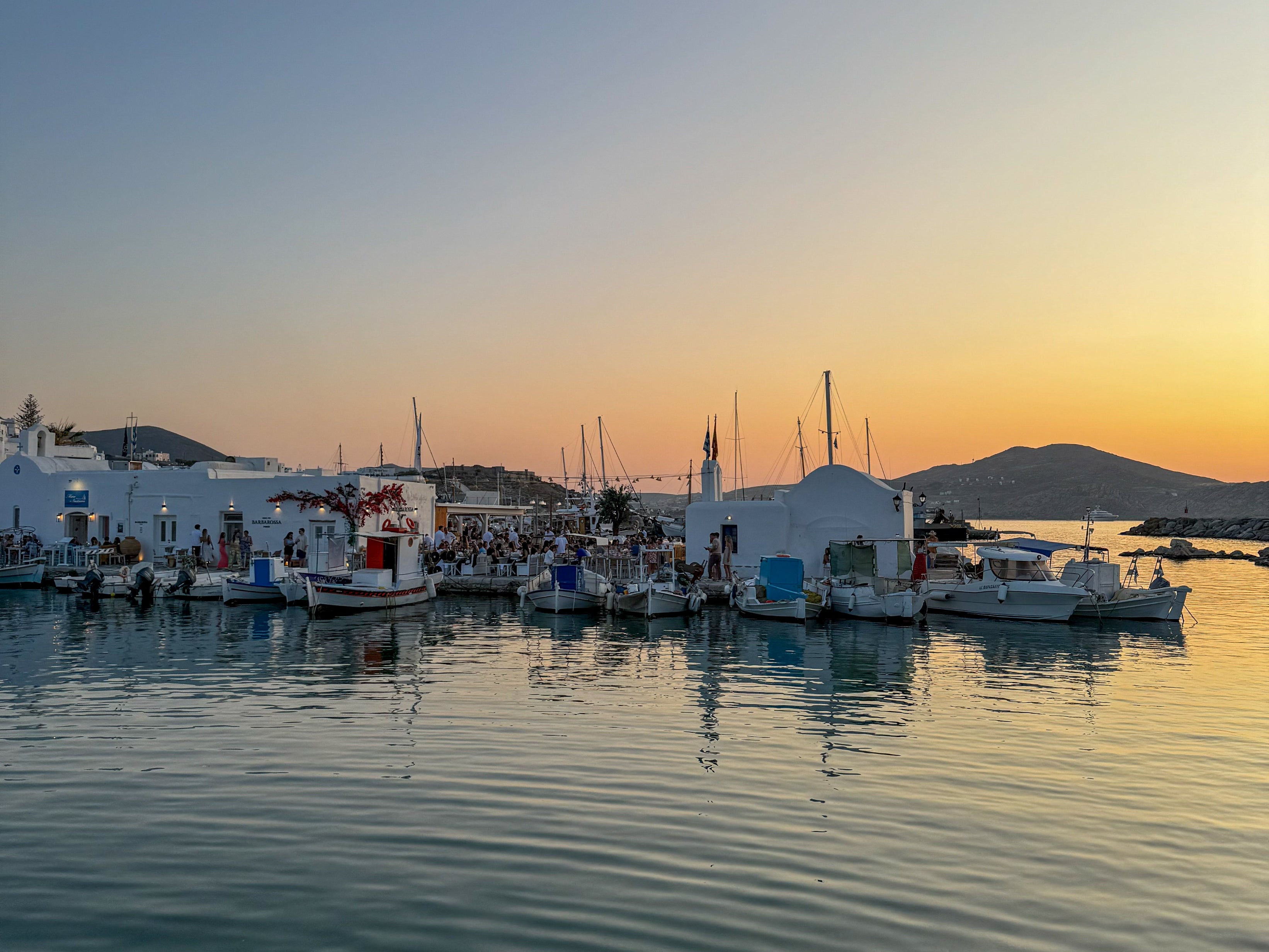 Marina with boats at sunset, mountains in the background
